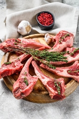 Raw fresh lamb rib chops with salt, pepper and herbs. Gray background. Top view