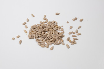 peeled sunflower seeds on white background.