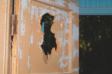 Hole in a broken door in a ruined building. abandoned house