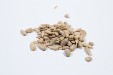 peeled sunflower seeds on white background.