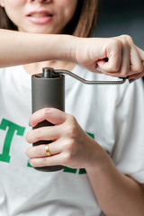 Thandland Bangkok 8 Aug 2020 : A woman's hand grinding coffee with a coffee grinder.