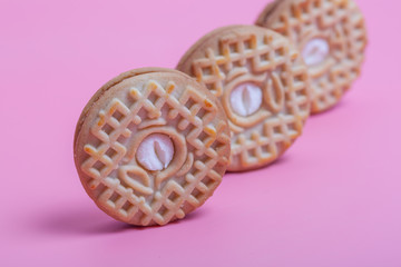 Cream sandwich biscuits on pink background