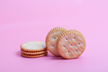 Cream sandwich biscuits on pink background