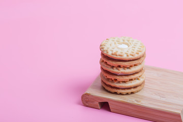 Cream sandwich biscuits on pink background