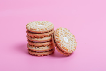 Cream sandwich biscuits on pink background