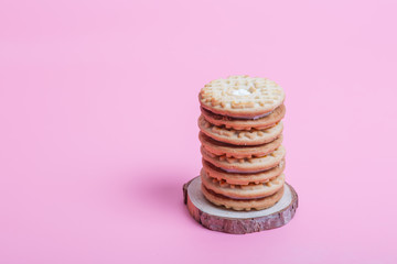 Cream sandwich biscuits on pink background