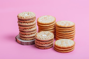 Cream sandwich biscuits on pink background