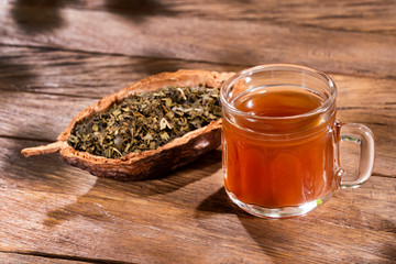 Cup of green tea with dried leaves - Camellia sinensis
