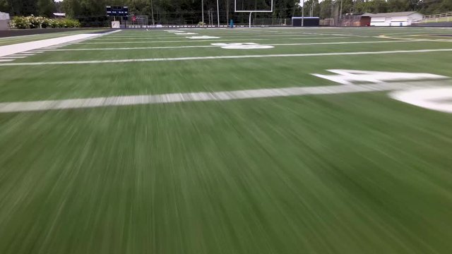 Drone flying over yard line numbers on a football field