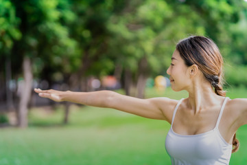 Healthy women doing yoga in the moring at the park . concept healthy and outdoor activity. Warrior2 pose