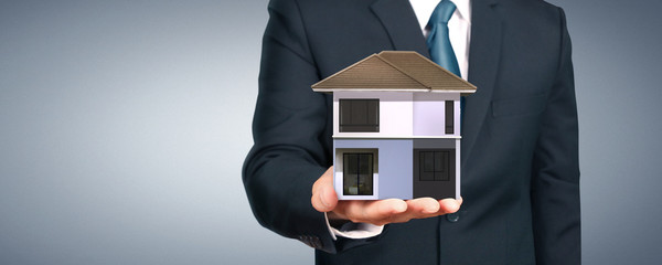 House model in hand there space. home, housing real estate concept