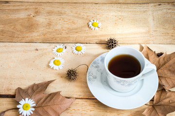 cup of coffee and flowers on wooden table