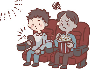 映画上映中にスマートフォンを見る男性