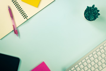 Minimalist Background and Spiral Notebook or Spring Notebook with Stationery such as Pen and Color Sticky Note and Computer Keyboard and Tablet and Tree on Blue Pastel Background in Vintage Tone