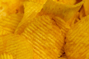 Corrugated potato chips, the texture of the surface. Close up.