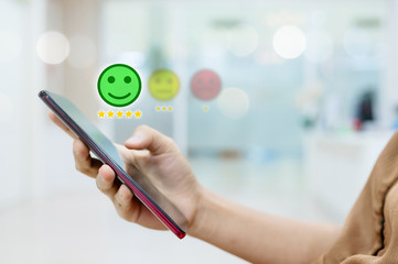 Customer Service Experience and Business Satisfaction Survey. Woman choose face smile on smart phone