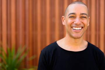 Happy handsome multi ethnic bald man in the streets outdoors