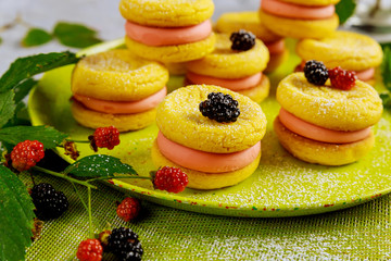 Sandwich lemon cookies with red and black berries.