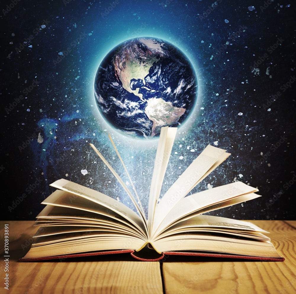 Wall mural old open book on a space and planet background