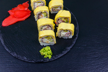 Sushi cheese rolls on a black slate