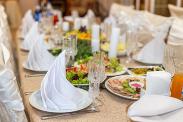 Tasty dishes on a served white banquet table in a luxury restaurant.