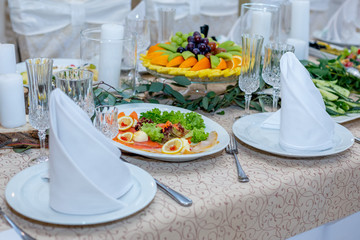 Tasty dishes on a served white banquet table in a luxury restaurant.