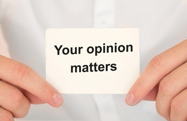 Man's hands take a card with words Your opinion matters, finance and business concept.