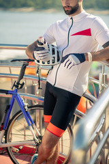 Athletic cyclist with sports water bottle and helmet