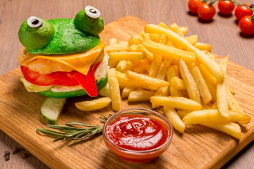 Crazy frog burger on a wooden board.