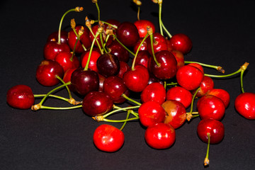 Obraz na płótnie Canvas red cherries on black background