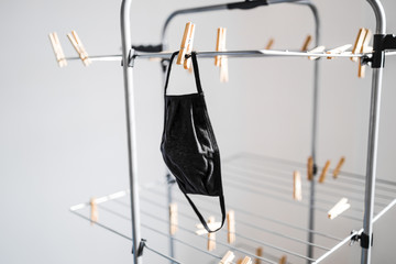 the new normal after the covid-19 pandemic, reusable fabric face mask just washed and hung to dry on clothes airer