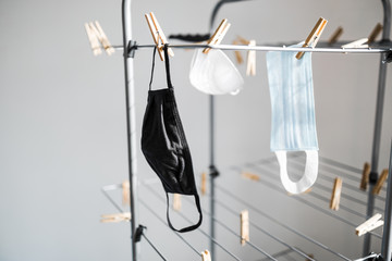 the new normal after the covid-19 pandemic, different types of face masks hung to dry on clothes airer