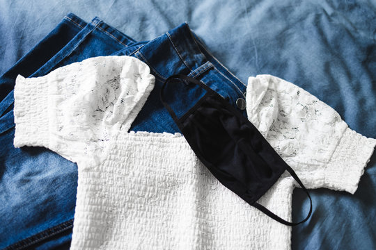 the new normal after the covid-19pandemic, woman's outfit of the day with reusable fabric face mask on top of clothes to wear