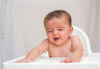 cute infant play with water on baby chair