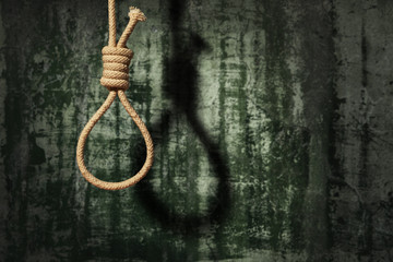 suicide concept. noose with shadow on dark wall background