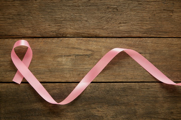 Pink ribbon on wooden breast cancer awareness background concept