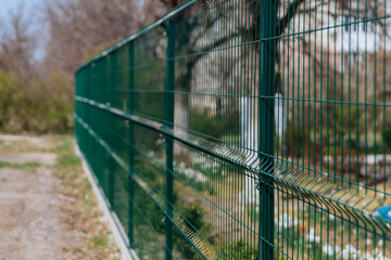 Steel grill. Green fence with wire. Fencing