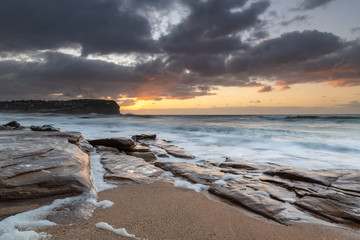 Fototapeta na wymiar Sunrise at the beach with waves and clouds