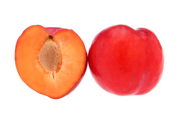 Isolated plums. One and a half of red plum fruit with leaves isolated on white background.