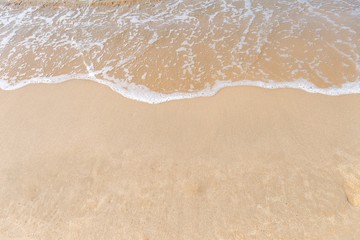 Fototapeta na wymiar Beach background, white wave on clean sand beach, summer outdoor day light, nature concept background