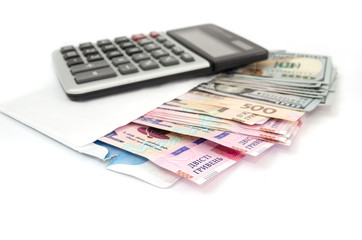 calculator, dollars and hryvnia in a white envelope on a white background.