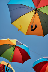 Rainbow colored umbrellas hanging in the sky. Summer travel. LGBT pride