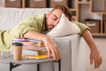 Tired male student sleeping at home