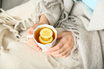 Woman with cup of hot tea at home