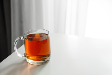 Cup of hot tea on table