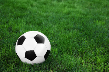 Fototapeta na wymiar Soccer ball on green grass outdoors