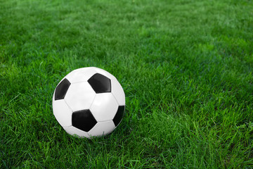 Fototapeta na wymiar Soccer ball on green grass outdoors