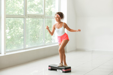 Young woman doing aerobics in gym