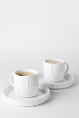 Cups of hot coffee on white background