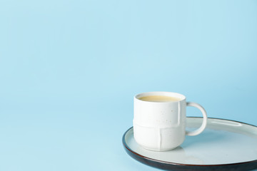 Cup of hot coffee on color background